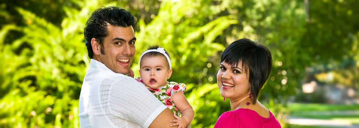 family posing in front of trees